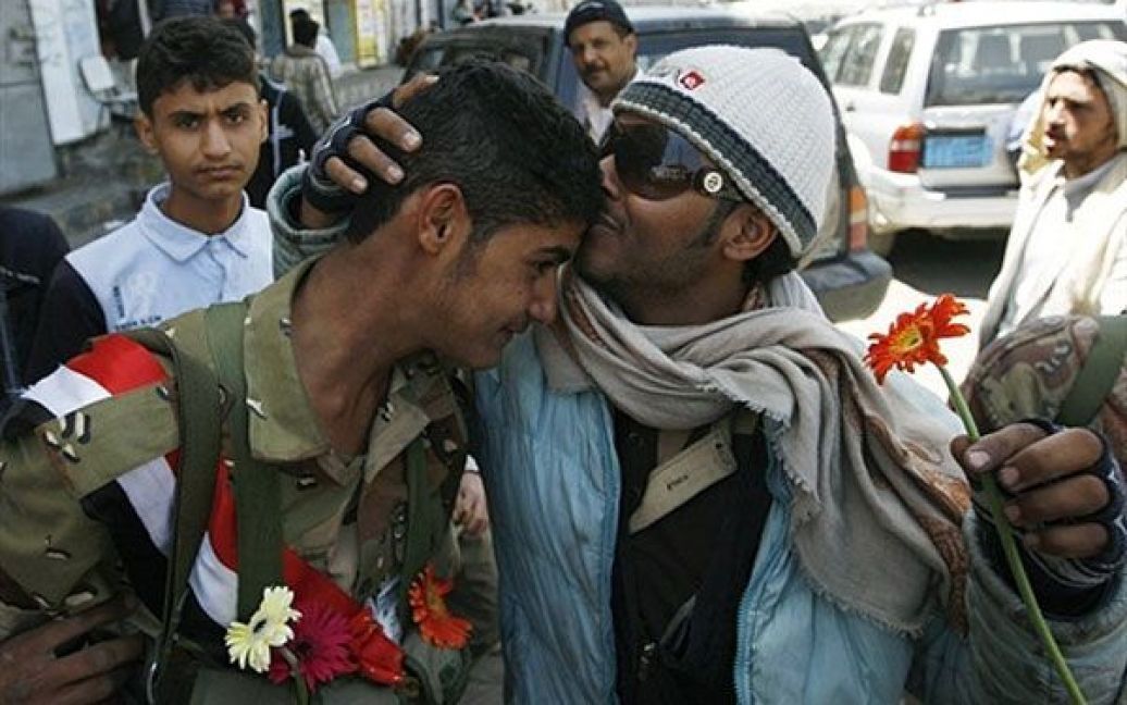 Ємен, Сана. Єменського солдата цілує учасник акції протесту під час демонстрації проти президента країни Алі Абдалли Салеха в Сані. Єменські депутати проголосували за введення в країні надзвичайного стану. / © AFP