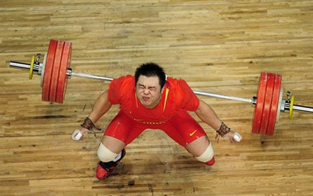 Китай, Гуанчжоу. Китайський важкоатлет Ян Чже реагує після перемоги у
вазі 105 кг на 16 Азіатських іграх в Гуанчжоу. / © AFP