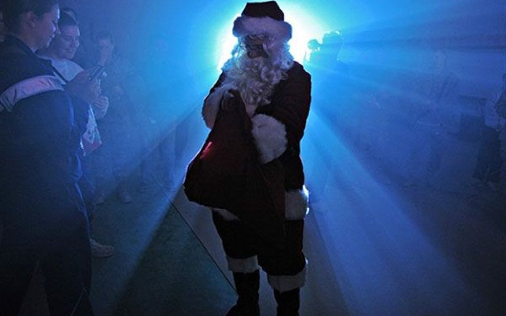 Афганістан, Баграм. Санта Клаус вносить подарунки для американських військових під час різдвяного концерту на авіабазі Баграм. Президент Афганістану Хамід Карзай побажав веселого Різдва іноземним військовим. В Афганістані наразі перебувають близько 113 тисяч міжнародних військових зі США та країн НАТО. / © AFP