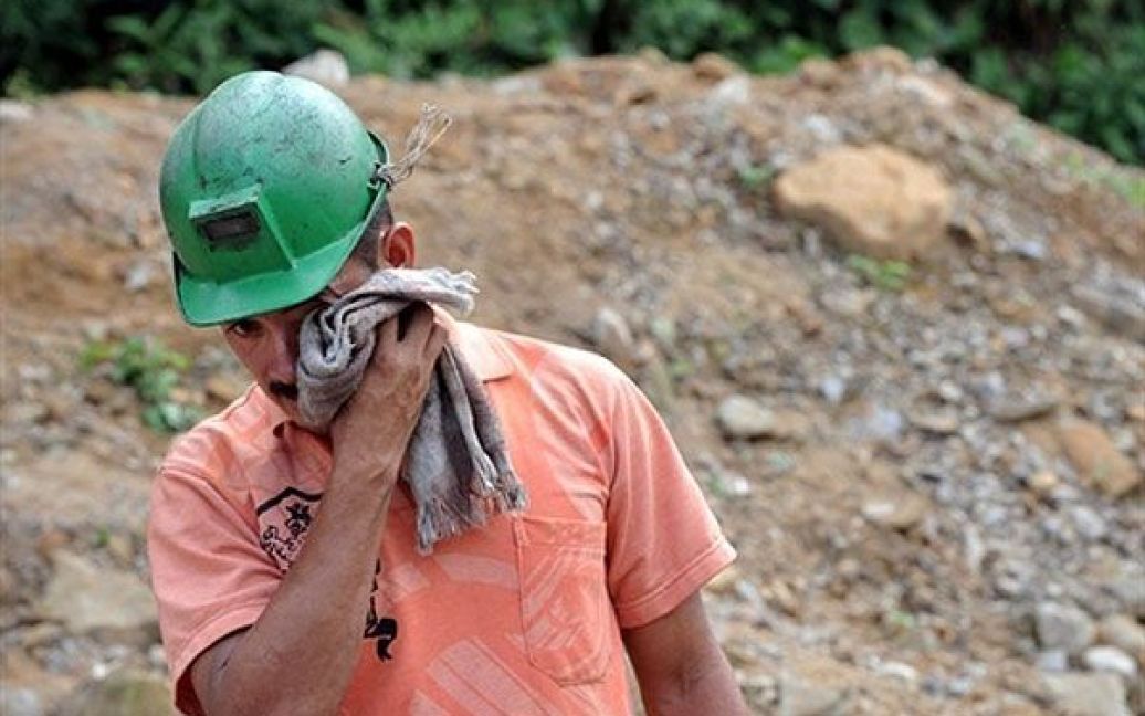 Колумбія, Сардіната. Шахтар Орландо Мендес стоїть поруч із шахтою, звідки піднімають тіла його колег, що загинули під час аварії на шахті "La Preciosa" у Сан-Роке, муніципалітет Сардіната. 21 шахтар загинув в результаті вибуху на вугільній шахті "La Preciosa", 17 осіб були врятовані із заваленої шахти. / © AFP