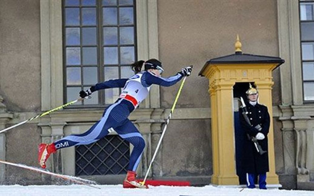 Швеція, Стокгольм. Фінський спортсмен Айно Кайса Саарінен проїжджає повз почесну охорону Королівського палацу під час кваліфікаційної гонки на Кубку світу Royal Palace Sprint. / © AFP