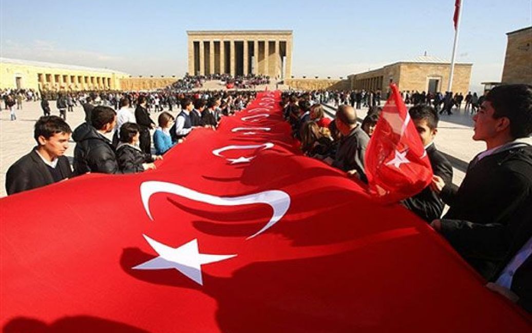 Туреччина, Анкара. Люди тримають національний прапор Туреччини перед мавзолеєм Мустафи Кемаля Ататюрка під час відзначення 72-ї річниці його смерті. Ататюрка, який оголосив сучасну Туреччину у 1923 році на руїнах Османської імперії, вважають національним героєм і вшановують до цього дня. / © AFP