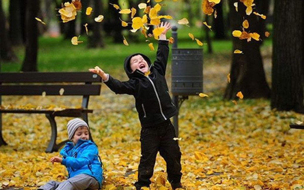 Румунія, Бухарест. Діти грають з осіннім листям у парку в Бухаресті. / © AFP