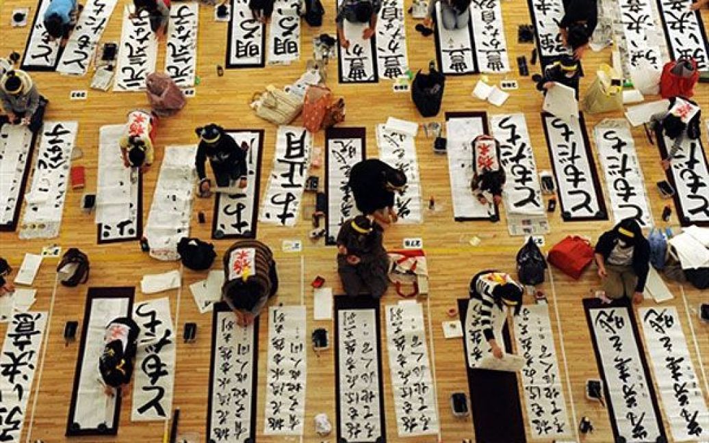 Японія, Токіо. Люди пишуть ієрогліфи на 47-му щорічному новорічному конкурсі з каліграфії у Токіо, в якому взяли участь майже 3000 людей. / © AFP