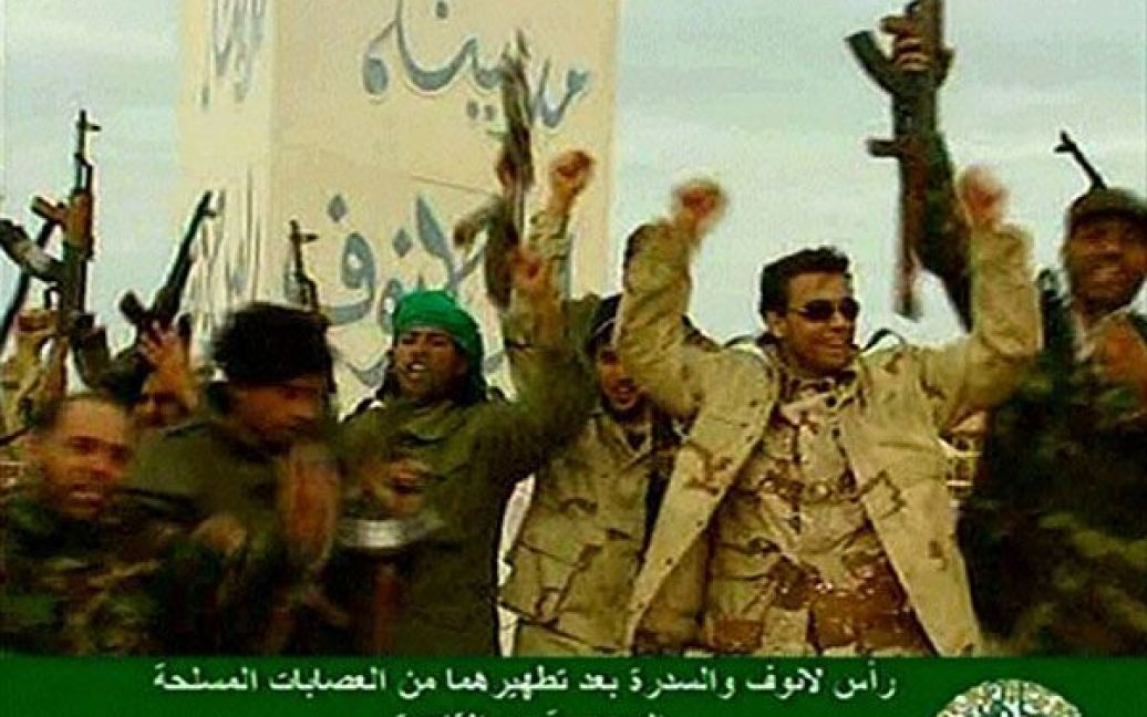 Лівійська Арабська Джамахірія, Рас Лануф. Лівійські урядові військові, які підтримують лідера країни Муаммара Каддафі, святкують після того, як вони відбили місто Рас Лануф у антиурядових повстанців. Фото AFP/LIBYAN TV / © AFP