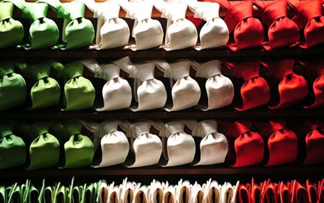 Італія, Мілан. Пакунки зелених, білих і червоних стрічок, які символізують національний прапор Італії, виставлені на вітрині магазину в Мілані під час святкування 150-річчя об&#039;єднання Італії. / © AFP