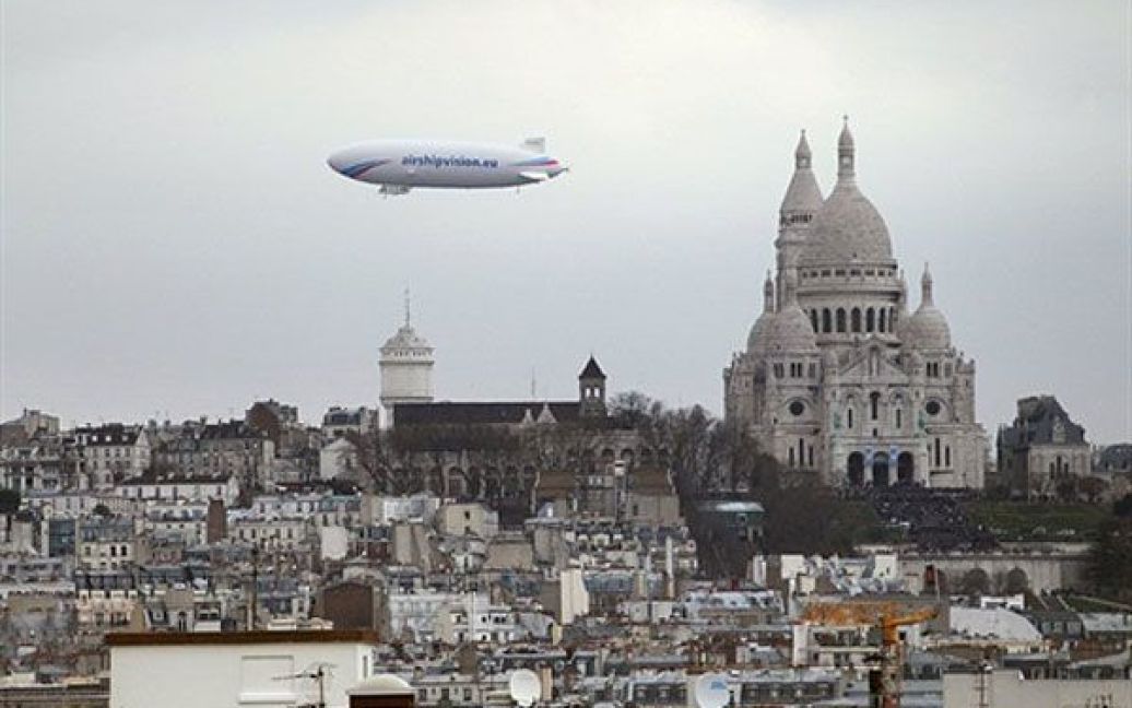 Франція, Париж. Дирижабль "Zeppelin" пролітає повз дах собору Сакре-Кер у Парижі. Дирижаблі вимірюють рівня радіоактивності у Парижі. / © AFP