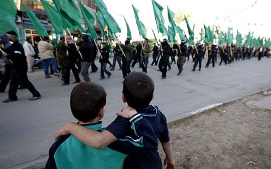 Хан-Юніс. Палестинські діти дивляться на бойовиків руху "Хамас", які беруть участь у марші в таборі біженців Хан-Юніс у південній частині сектора Газа. / © AFP
