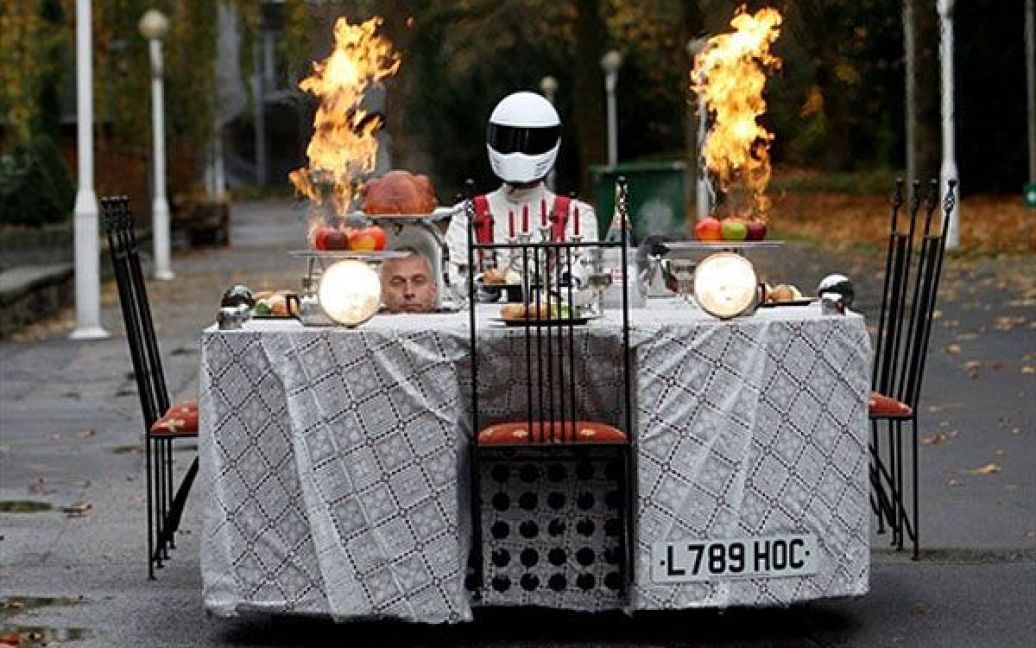 Німеччина, Ессен. Британський конструктор Перрі Уоткінс їде на автомобілі, схожому на обідній стіл, під час презентації напередодні ярмарку "Моторшоу" в Ессені. / © AFP