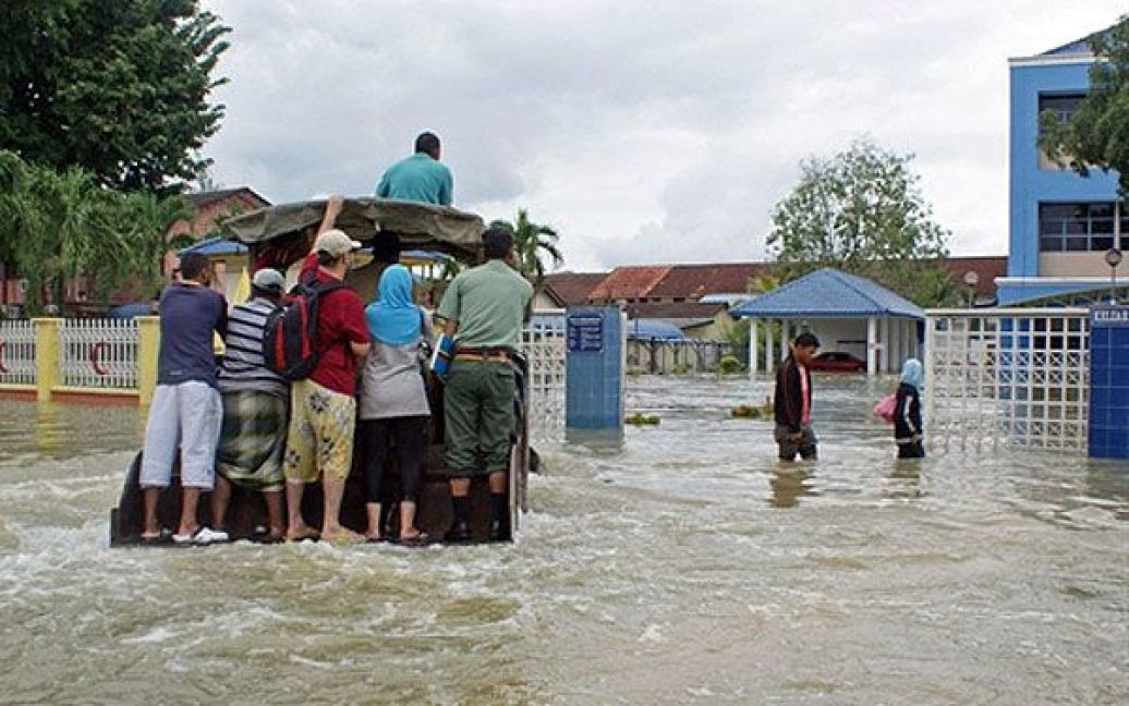 Малайзія, Кангар. Мешканці на вантажівці переміщаються затопленим містом Кангар у північній провінції Малайзії. Більше 6 тисяч людей були евакуйовані з провінції, яка потерпає від повені. / © AFP