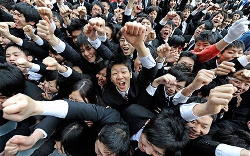 Японія, Токіо. Студенти коледжу піднімають руки і кричать перед початком церемонії пошуку роботи в Токіо. Близько 1500 студентів, які стануть випускниками у березні 2012 року, взяли участь у щорічній церемонії самостійного пошуку роботи. / © AFP