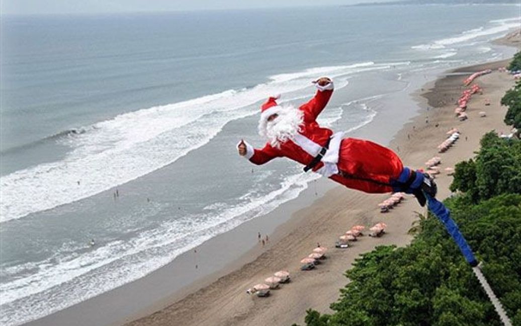 Індонезія, Кута. Чоловік у костюмі Санта Клауса стрибає з банджи на пляжі в Куті, Балі. / © AFP