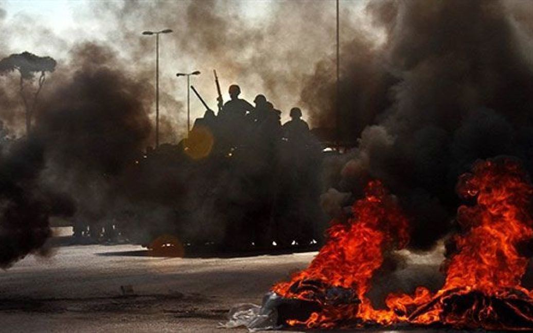 Ліван, Бейрут. Ліванські солдати дивляться на шини, які підпалили прихильники "Руху за майбутнє" на околиці Бейрута під час демонстрації на підтримку прем&#039;єр-міністра Саада Харірі. / © AFP