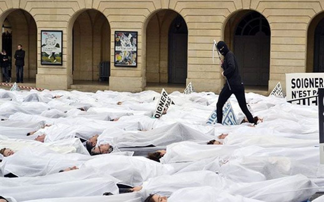 Франція, Париж. Люди лежать на тротуарі під час проведення акції протесту, яку організував Альянс "Право на життя" поблизу Сенату в Парижі, де розглядали законопроект проти легалізації евтаназії. / © AFP