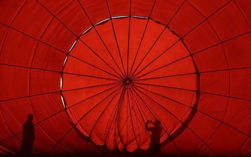 Філіппіни, Пампанга. Силуети відвідувачів 16-го Міжнародного фестивалю повітряних куль на базі Кларк Фріпорт. Фестиваль проходить на колишній американській військовій авіабазі поблизу Маніли щороку, починаючи з лютого 1994, і залучає тисячі глядачів. / © AFP