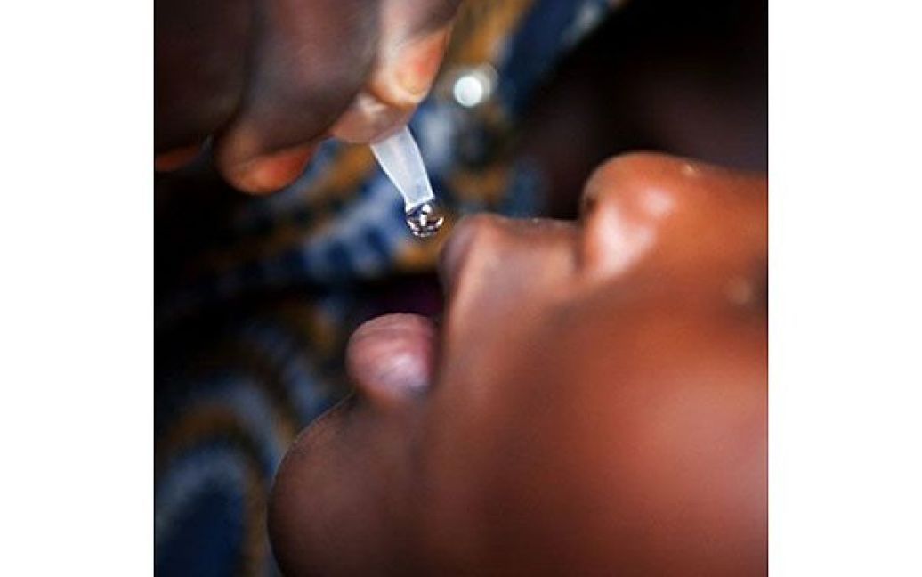 Демократична Республіка Конго, Лубумбаші. Співробітник Міністерства охорони здоров&#039;я здійснює вакцинацію проти поліомієліту конголезькій дитині під час першого дня національної кампанії масової імунізації проти поліомієліту. У кампанії беруть участь 15 африканських країн, в яких на цьому тижні було проведено імунізацію 72 мільйонів дітей. / © AFP