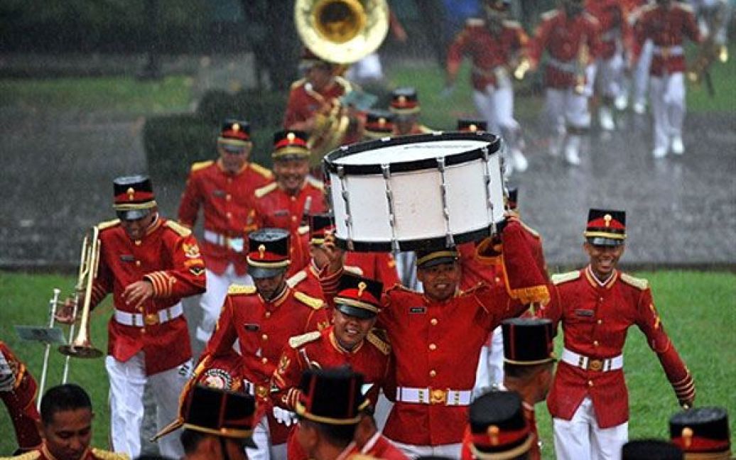 Індонезія, Джакарта. Музиканти тікають від дощу за кілька хвилин до початку офіційної церемонії прибуття президента США Барака Обами до Палацового комплексу Істана Мердека у Джакарті. / © AFP