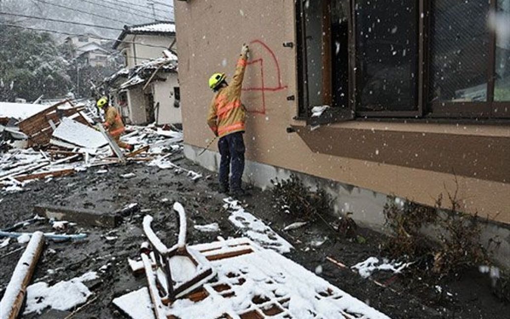 Японія, Камаісі. Член американської пошуково-рятувальні команди Фейрфакс з Вірджинії помічає будинок, щоб показати, що будинок обшукали і не знайшли там жодних жертв землетрусу. / © AFP
