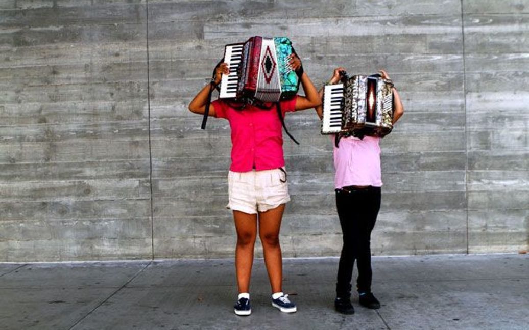 14-річна Джоан Нахью та її 10-річна сестра Алеа Нахью з акордеонами стоять на Мейн Стріт у Лос-Анджелесі. Дівчата грають на акордеонах за милостиню поряд з офісами юридичних фірм, де працюють їхні родичі. (Mel Melcon/Los Angeles Time) / © Los Angeles Times