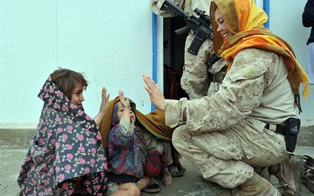 Афганістан, Гамсер. Жінки, які є морськими піхотинцями армії США, спілкуються з афганськими дітьми під час візиту до Гамсера, провінція Гільменд. / © AFP