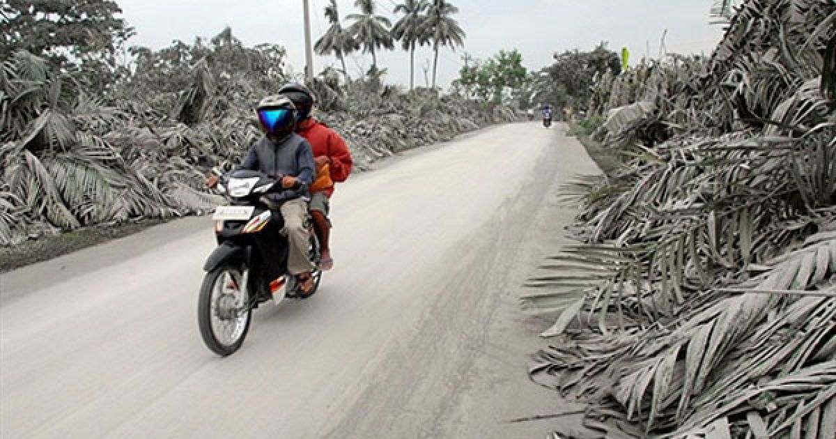 Індонезія, Слеман. Місцеві мешканці на мотоциклі їдуть крізь село, вкрите вулканічним попелом у центральній частині Яви. Через виверження вулкана Мерапі у Індонезії загинули 85 осіб, велика кількість людей отримала важкі опіки. / © AFP