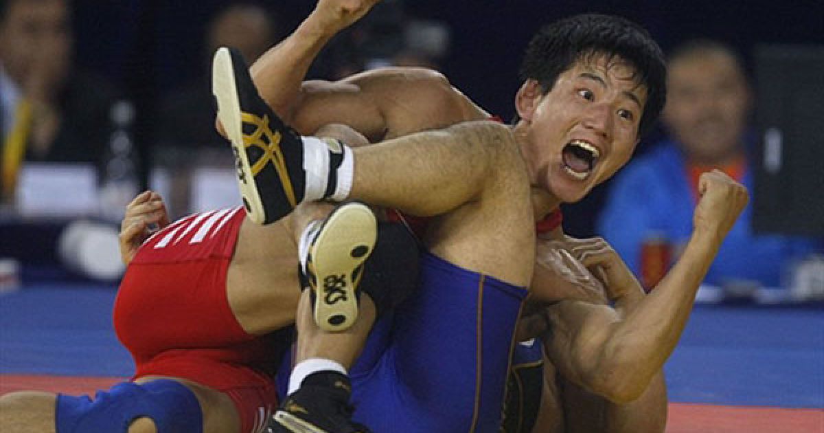 Китай, Гуанчжоу. Монгольський спортсмен Мандахнаран Ганзоріг святкує перемогу над японцем Хіроюкі Ода під час змагань з вільної боротьби у ваговій категорії 60 кг на Азіатських іграх у Гуанчжоу. Монголія завоювала золото, срібну медаль &ndash; Японія, бронзу поділили Китай і Казахстан. / © AFP