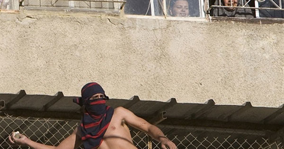 Єрусалим. Палестинський юнак кидає каміння у ізраїльських військових під час акції протесту в арабському районі Єрусалиму Сильван. / © AFP