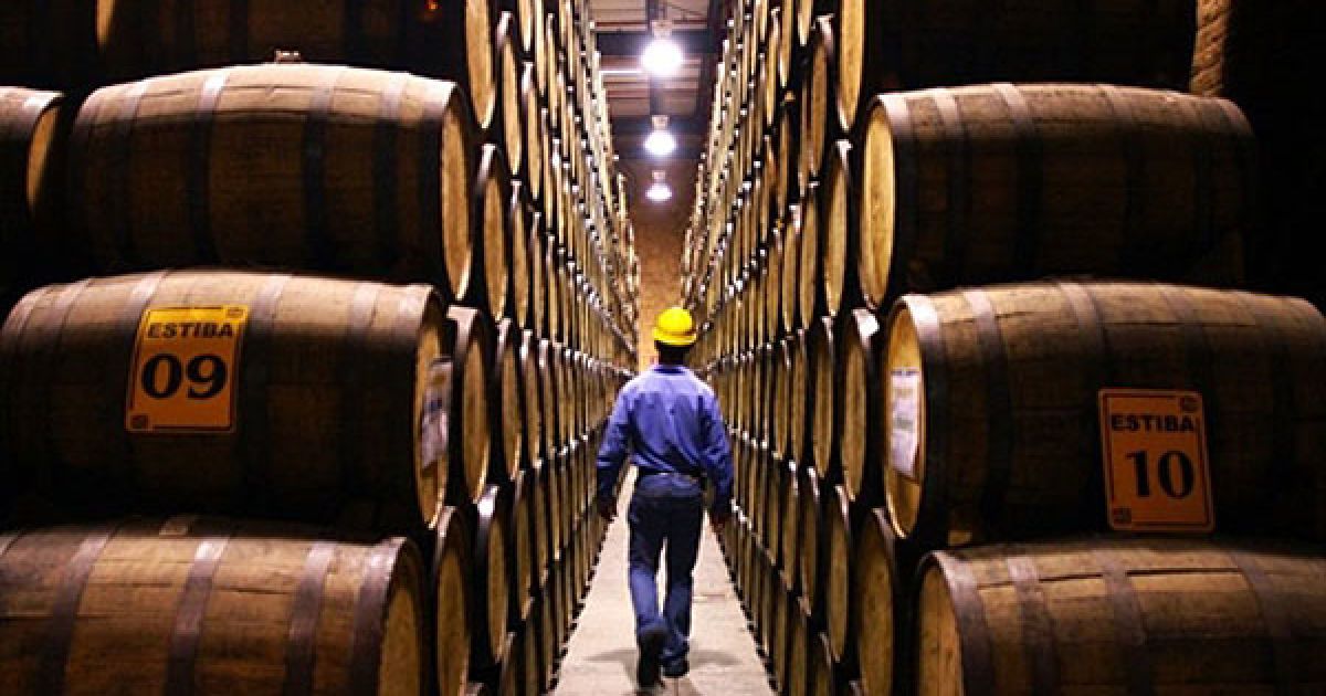 Мексика. Працівник лікеро-горілчаного заводу "Patron Distillery" йде повз бочки з текілою у виробничому цеху. / © AFP