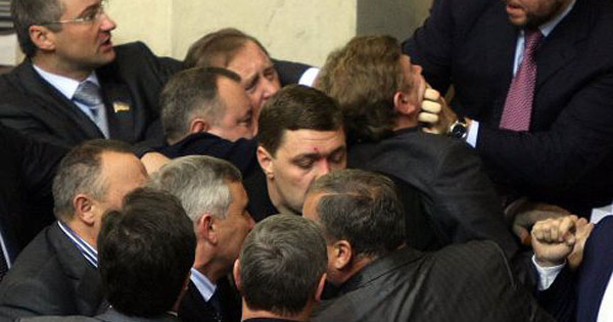 Після того, як бютівці Роман Забзалюк, Сергій Сас, Андрій Павловський висипали на стіл голови уряду, де сидів міністр фінансів, монети, керівник Мінфіну схопив один з томів Податкового кодексу та жбурнув ним у бютівців. / © УНІАН