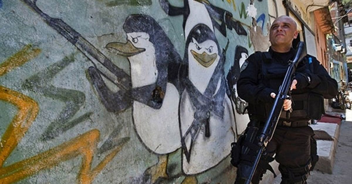 Бразилія, Ріо-де-Жанейро. Озброєний поліцейський стоїть на сторожі під
час рейду у нетрях Алемао в Ріо-де-Жанейро. / © AFP