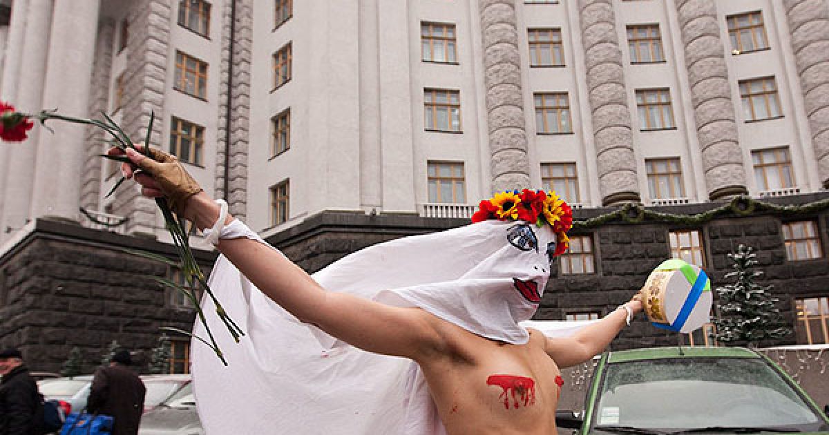 Активістка руху FEMEN в образі "кровосісі" спробувала прорватися до будівлі Кабінету міністрів і особисто вручити Миколі Азарову квіти і торт. / © Жіночий рух FEMEN