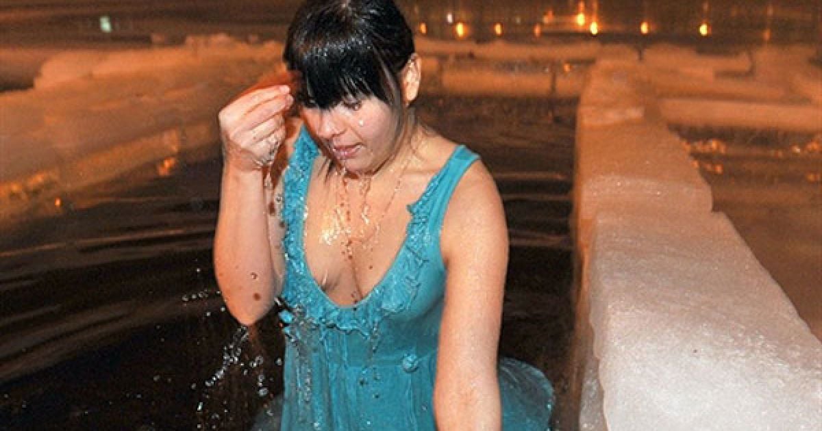 Білорусь, Мінськ. Жінка стоїть у ополонці на озері Комсомольське в центрі Мінська під час купання на свято Водохреща. Православні і греко-католики у всьому світі відсвяткували Богоявлення, одне з найбільших свят у календарі православних. / © AFP