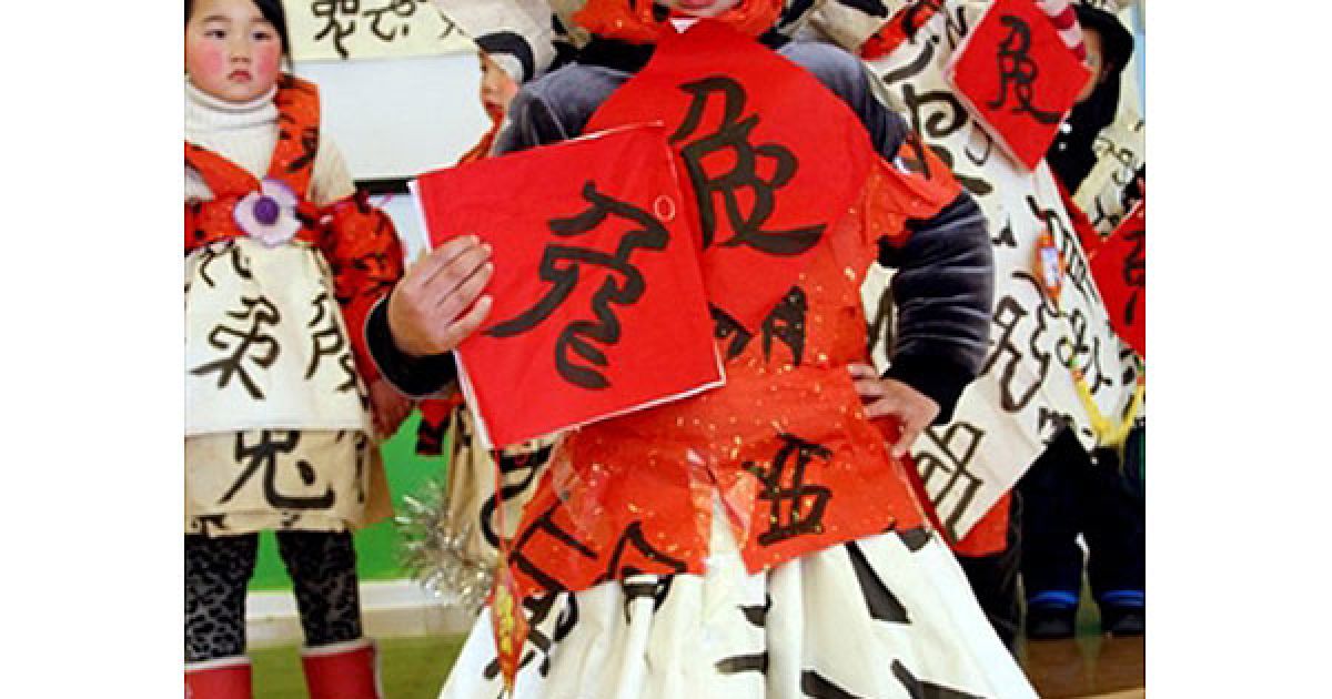 Китай, Ханшан. Китайська дівчина позує поруч із плакатом, на якому зображено китайський ієрогліф "кролик", під час конкурсу каліграфії напередодні святкування місячного Нового року, року Кролика, у школі міста Ханшан, провінція Аньхой. / © AFP