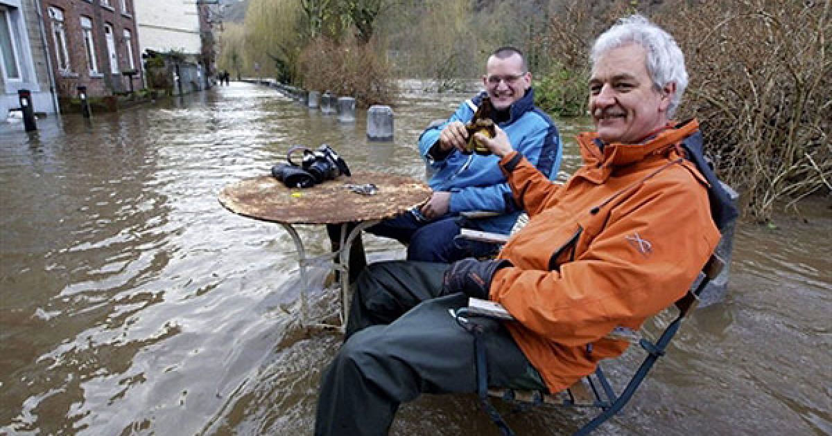 Чоловіки п&rsquo;ють пиво на затопленій вулиці міста Еньо (Бельгія), поблизу річки Урт / © AFP
