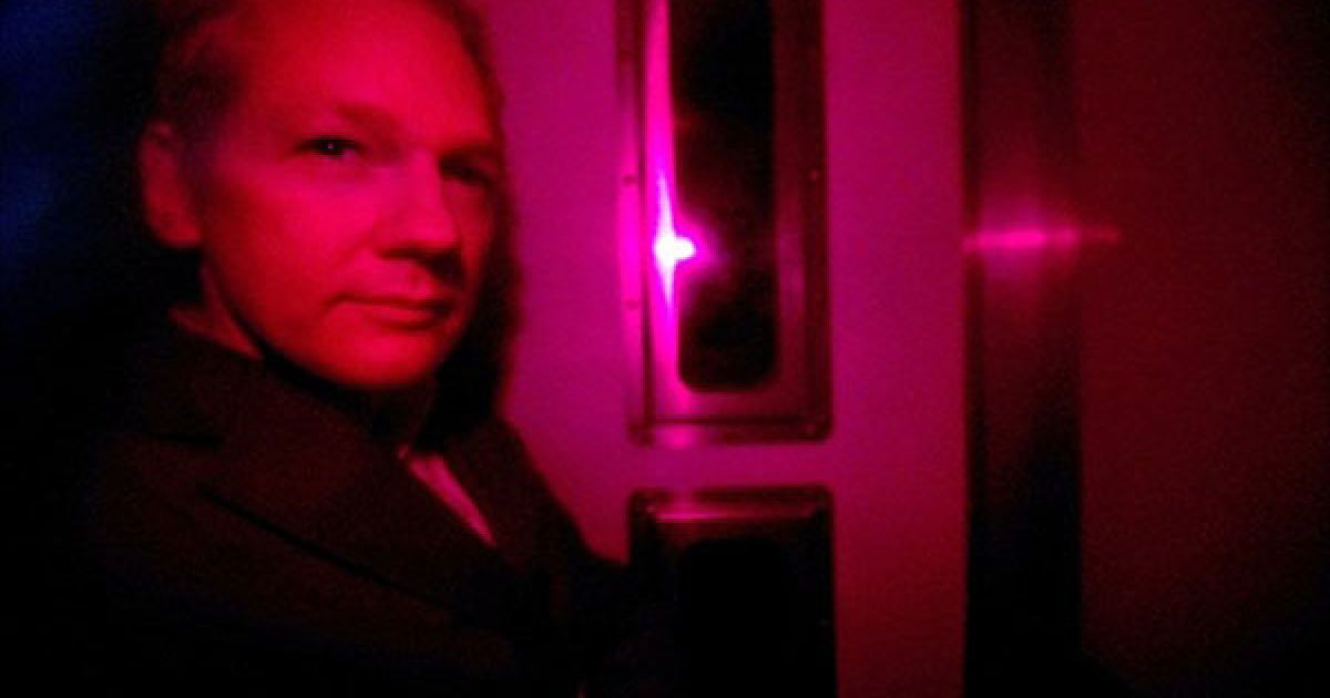 Великобританія, Лондон. Засновника Wikileaks Джуліана Ассанжа видно крізь тоноване скло поліцейського автомобіля. Ассанжа привезли до Вестмінстерського мирового суду в Лондоні. Компанії Visa, MasterCard та PayPal заблокували можливість робити пожертви на сайті Джуліана Ассанжа, про що він заявив з-за грат. / © AFP