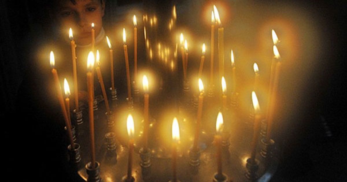 Киргизстан, Бішкек. Хлопчик запалює свічку під час служби у церкві міста Бішкек. Православні християни святкують Різдво за старим юліанським календарем. / © AFP