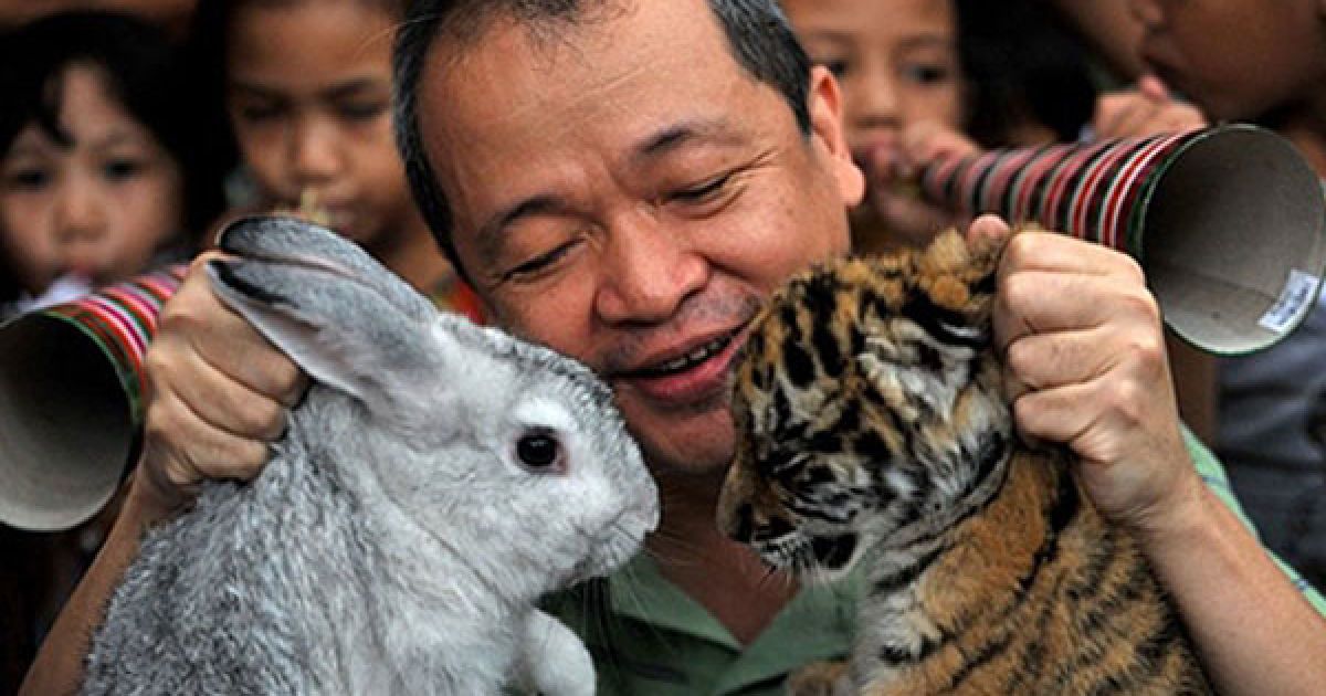 Філіппіни, Маніла. Власник зоопарку "Малабон" Менні Тангко тримає в руках кролика і тигреня, які ілюструють перехід від року Тигра до року Кролика. У Китаї та багатьох інших частинах Азії у лютому 2011 року відзначатимуть початок року Кролика за китайським календарем. / © AFP
