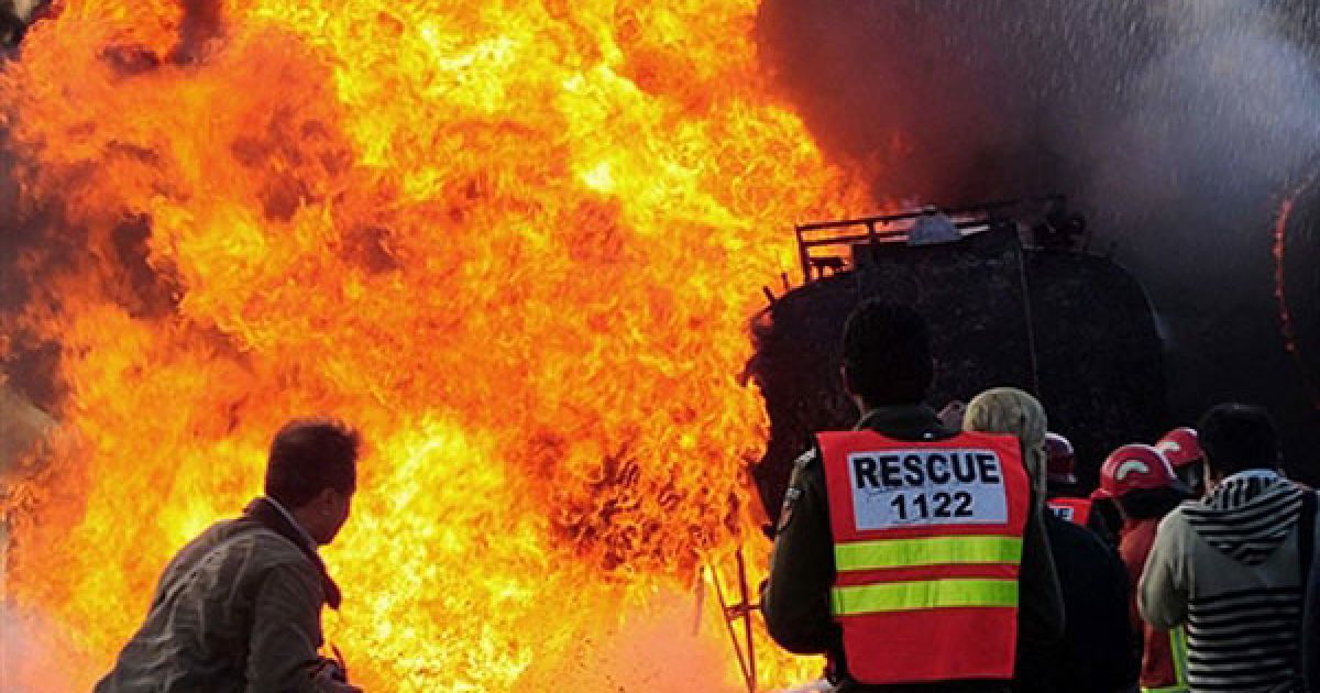 Пакистан, Пешавар. Пакистанські пожежні намагаються загасити палаючий нафтовий танкер НАТО після вибуху в Пешаварі. В результаті вибухів загинули троє співробітників служб безпеки, було знищено цистерни з нафтою. / © AFP