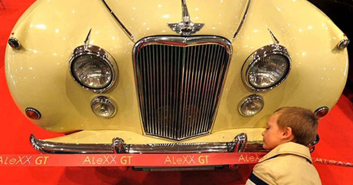 Україна, Київ. Хлопчик роздивляється "Jaguar Mark VII" (1955 р.в.) під час відкриття автосалону "Ретро і екзотика" у Києві. На автомобільгній виставці представлено близько 200 ексклюзивних старовинних автомобілів. / © AFP