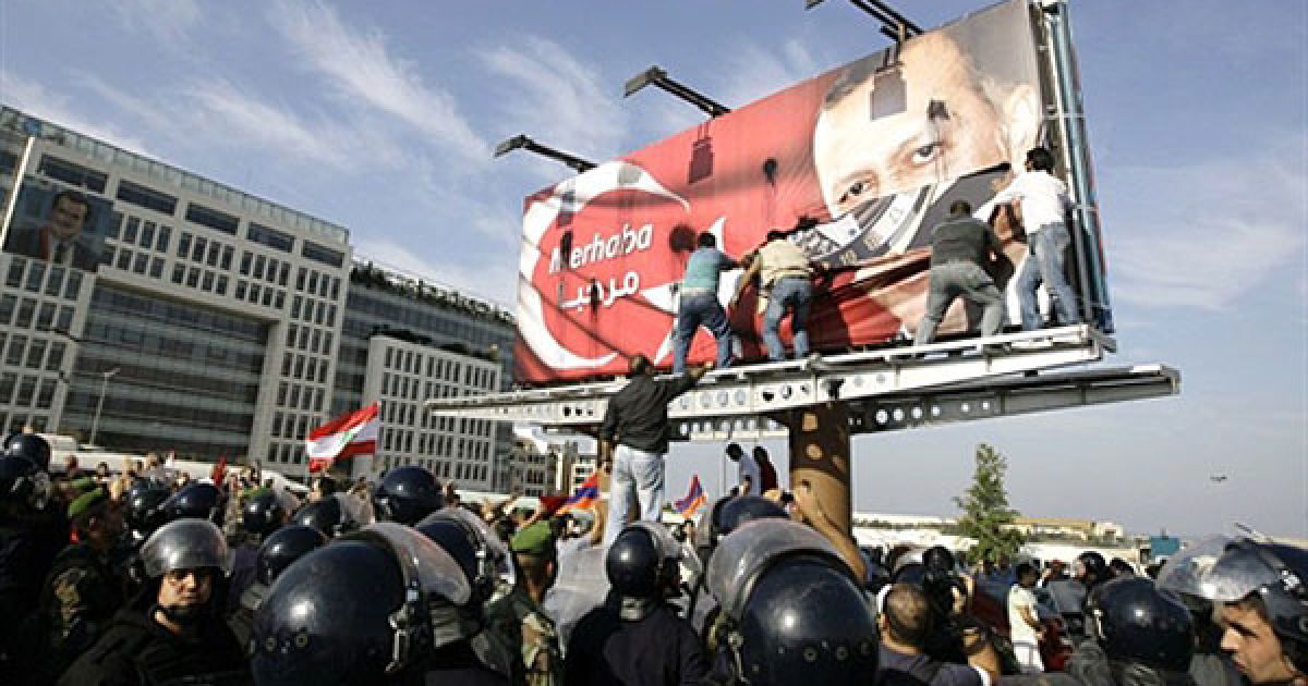Ліван, Бейрут. Поліцейські намагаються стримати мітингувальників, доки ліванські вірмени розривають плакат прем'єр-міністра Туреччини Реджепа Тайіпа Ердогана, вивішений у центрі Бейрута. Вірмени виступили із протестом проти візиту прем&rsquo;єр-міністра Туреччини до Лівану. / © AFP