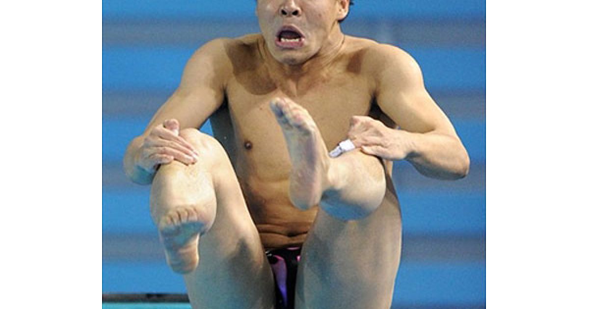 Китай, Гуанчжоу. Золотий призер Азіатських ігор, китайський спортсмен Він Чонг виконує стрибок з 3-метрового трампліна. Він Чонг набрав 525,85 очок і виграв золоту медаль. / © AFP