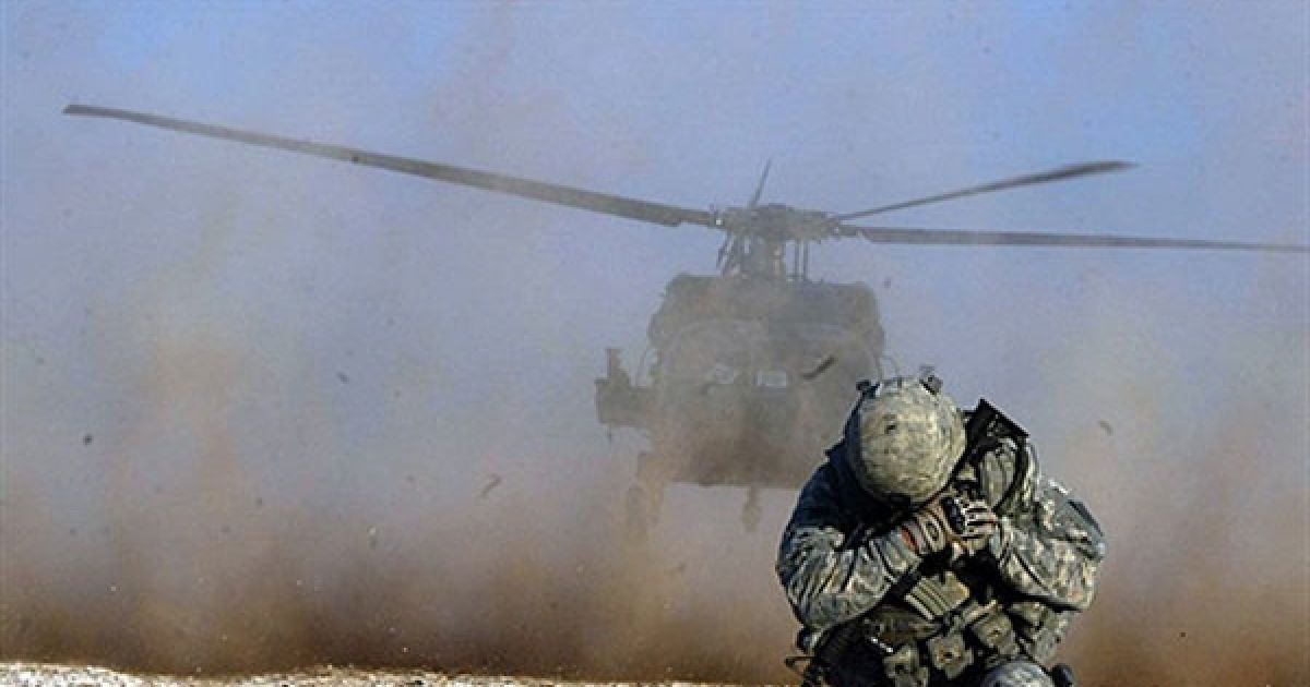 Ірак. Солдат захищає обличчя від пилу, доки злітає гелікоптер, під час спільного рейду американських і іракських сил, який провели у 100 км на південь від багатого на нафту міста Кіркук. Під час рейду військові затримали 25 розшукуваних осіб. / © AFP