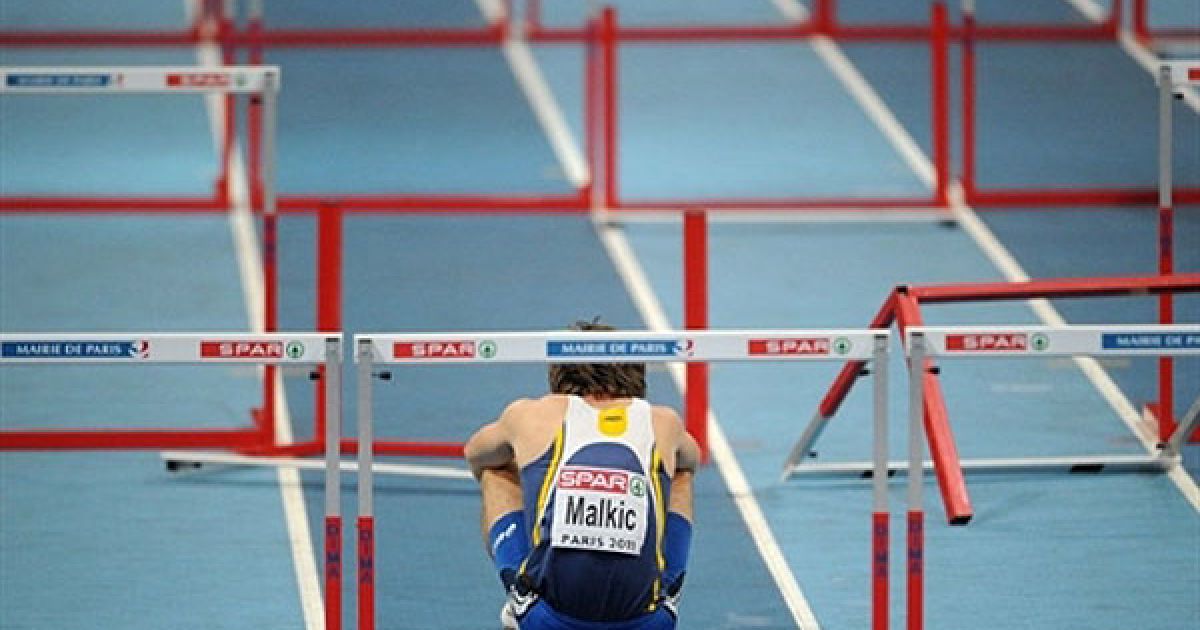 Франція, Париж: Боснійський спорсмтен Аднан Малкіч сидить на доріжці після падіння під час змагань з бігу з перешкодами у півфіналі Чемпіонату Європи з легкої атлетики у приміщеннях. / © AFP