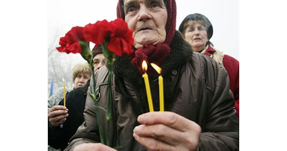 Україна, Донецьк. Літня жінка тримає квіти і свічки у пам&#039;ять про жертв Голодомору під час меморіальної церемонії в українському місті Донецьку. Мільйони українців померли від голоду у мирний час, трагедія Голодомору стала безпрецедентною катастрофою в історії України. / © AFP