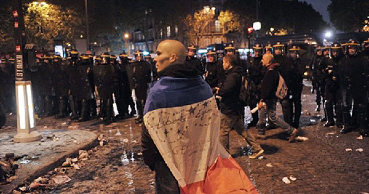 Франція, Париж. Чоловік стоїть перед поліцейськими під час демонстрації у Парижі, де протягом 9 днів проходили щоденні акції протесту проти урядової пенсійної реформи, який був офіційно прийнятий законодавцями / © AFP