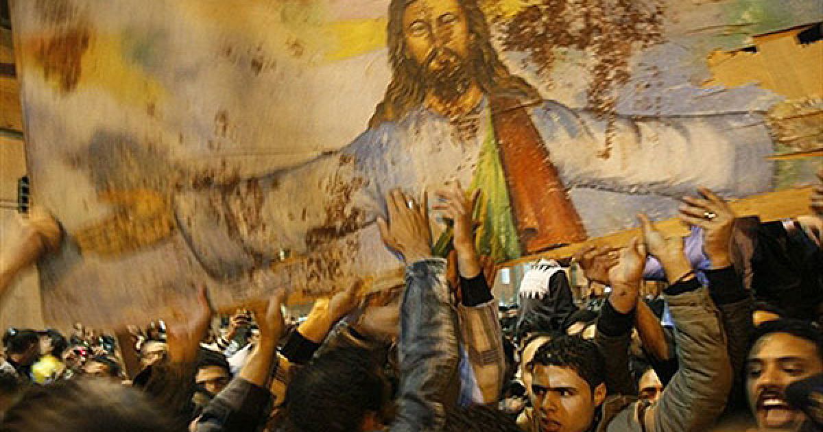 Єгипет, Олександрія. Єгипетські християни несуть закривавлений портрет Ісуса Христа під час акції протесту перед Церквою Святих у Олександрії. Напередодні Нового року перед церквою вибухнув начинений вибухівкою автомобіль, в результаті вибуху загинула 21 людина. / © AFP