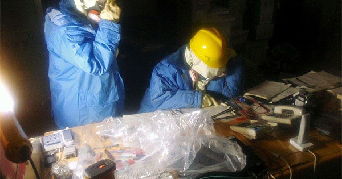 На головах ліквідаторів &mdash; захисні каски, обличчя повністю закриті масками, руки - гумовими рукавичками. / © AFP