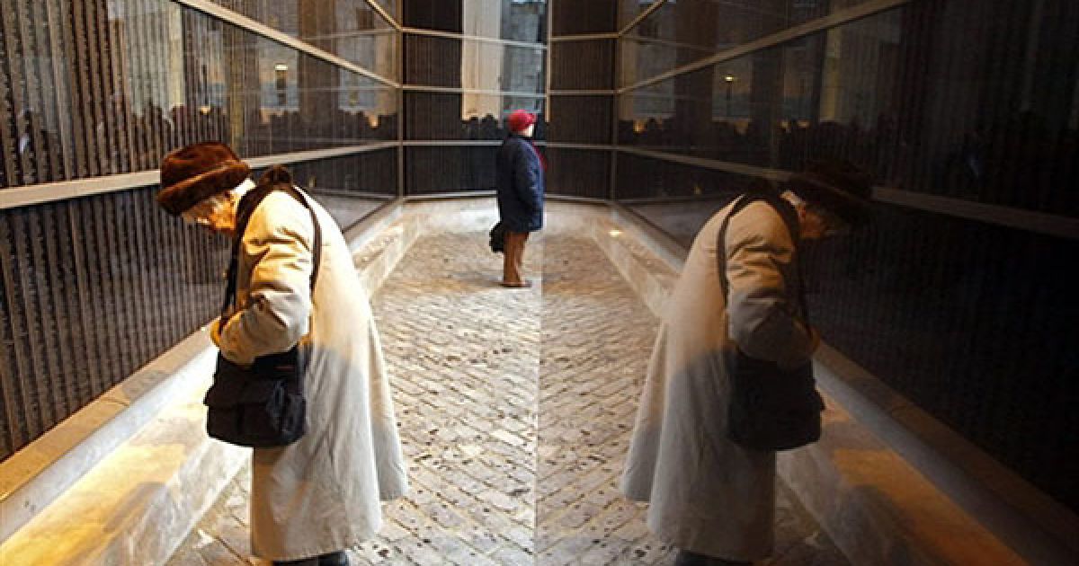 Угорщина, Будапешт. Жінка шукає імена родичів, жертв Голокосту, на Меморіальній стіні у Будапешті. У світі відзначили перший міжнародний день пам'яті жертв Голокосту. Цього року виповнилось 66 років з моменту звільнення в&rsquo;язнів нацистського табору смерті Освенцим, символу вбивства шести мільйонів євреїв під час Другої світової війні. / © AFP