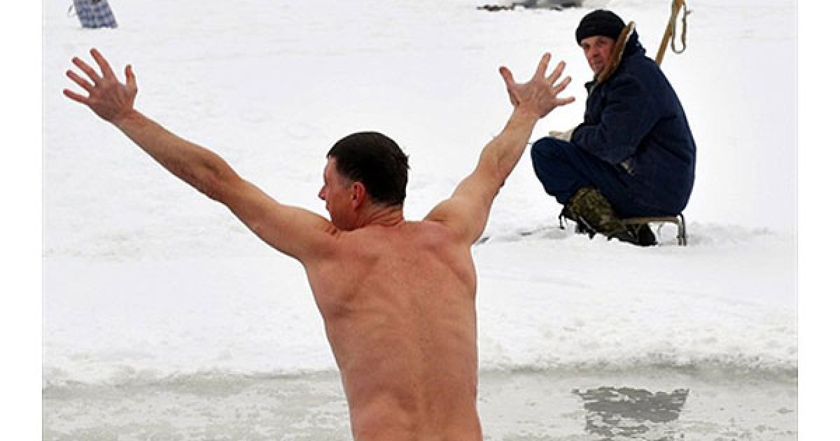 Білорусь, Мінськ. Чоловік пірнає у крижану воду озера Чіжовське у Мінську / © AFP