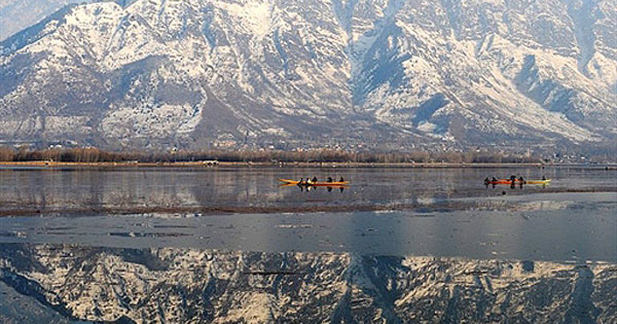 Індія, Срінагар. Люди пливуть на човнах озером Дав серед засніжених гір у Срінагарі. / © AFP
